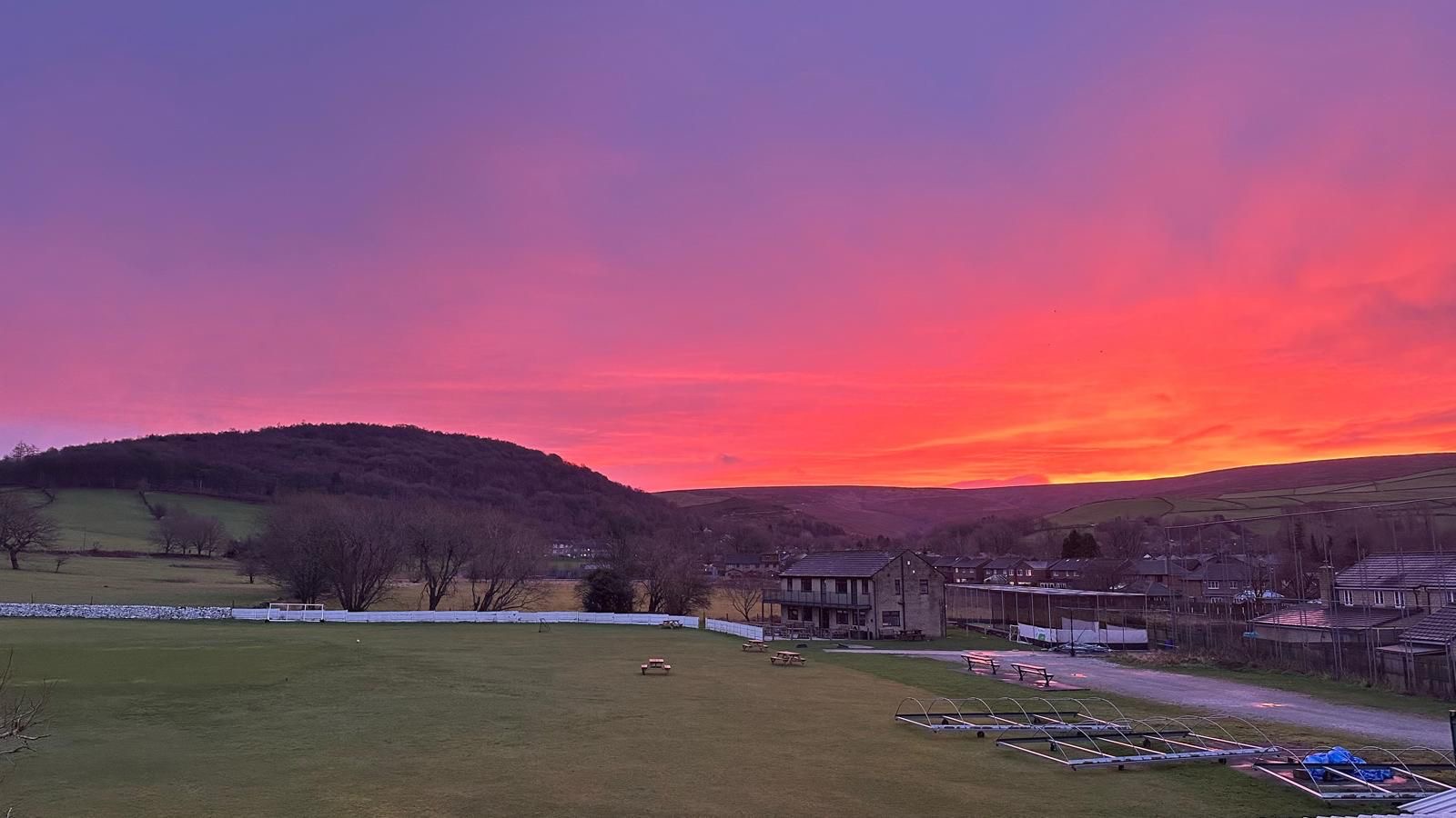 Old Glossop cricket pitch with the misted Peak District hills behind