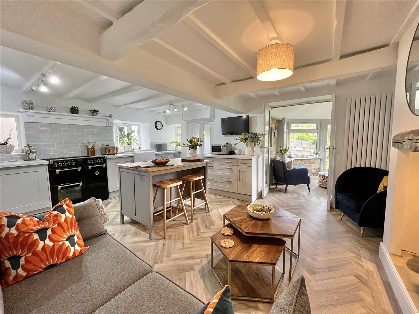 Refitted shaker kitchen with dove-grey cabinets, marble-look counters, black Stoves range and herringbone floor